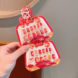 Close-up of red Chinese New Year press-on nails with cartoon lion and lantern patterns