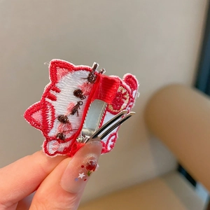 Detailansicht der roten Katzenhaarklammer mit silbernem Metall-Krokodilclip auf der Rückseite