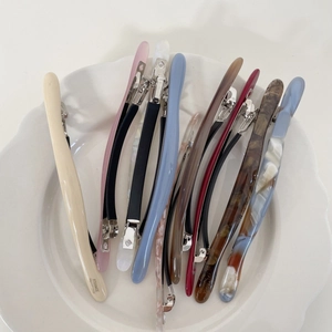 Set di fermagli per capelli in acetato fatti a mano in vari colori su piatto bianco