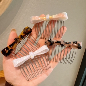 Detailed close-up of a 4-piece bow hair comb set in tortoise and marble patterns