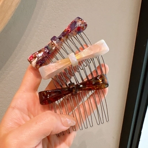 Three-piece set of acetate bow hair combs in tortoise, ivory and purple floral patterns