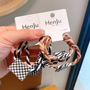 Detail of high-elasticity hair ties with checkerboard and zebra pattern charms