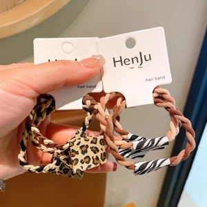 Detail of woven high-elastic hair bands with leopard and zebra print accents in earthy tones