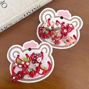 Vue détaillée d'élastiques à cheveux rouges festifs avec motifs cerise et ours