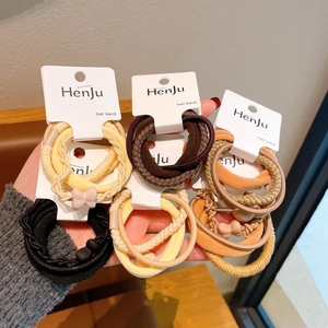 Set of high-elasticity hair ties in earth tones with matte bow charms on a card