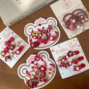 Gros plan d'un ensemble de barrettes fraise et lapin rouges sur une table en bois rustique