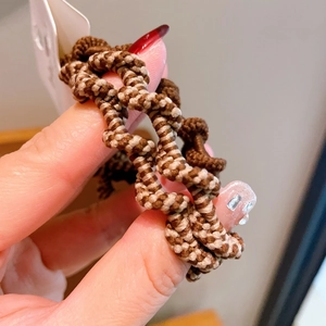 Close-up of brown and beige wavy braided spiral hair tie with high elastic texture