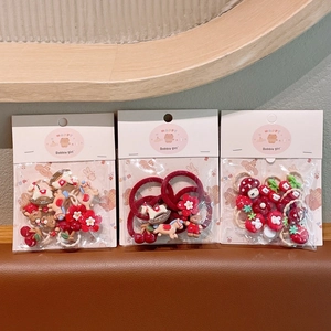 Detailoverzicht van drie schattige rode haaraccessoiresets met beren en kersenhangers