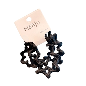Set of four black wave texture elastic hair ties displayed on a branded white paper card