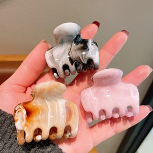 Three-piece acrylic hair claw set in marble, pink, and amber patterns for women