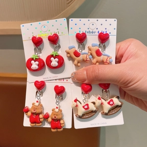 Close-up of cute cartoon princess ear clips with hearts, bears and rocking horses
