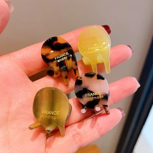 Set of four mini acetate hair claws in tortoise shell and leopard prints with gold lettering