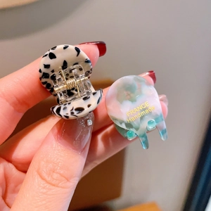 Macro shot of two mini acetate hair claws with marble and leopard patterns