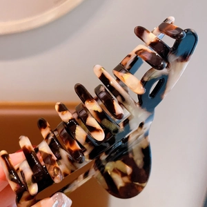 Detailed macro view of large tortoiseshell hair claw clip with strong metal spring mechanism