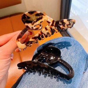 Detail of large acetate hair claws in tortoise and black finish with metal spring