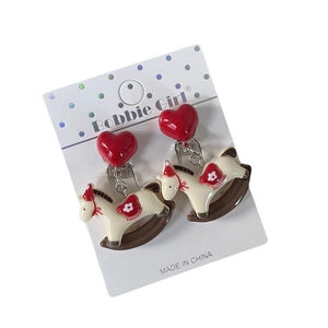 Cute red heart and rocking horse ear clips for girls on a white polka dot card