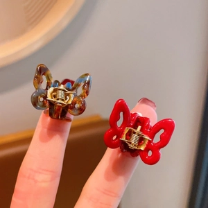 Macro shot of mini acetate butterfly hair claws in red and tortoiseshell patterns