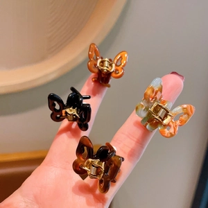 Set of 4 mini butterfly acetate hair clips in amber, black, and tortoise shell finishes