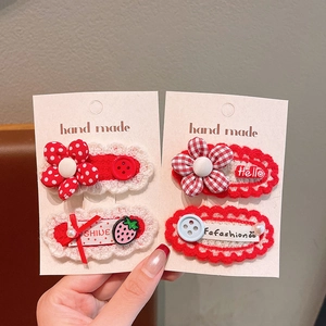 Detail van rood-witte handgehaakte haarspeldjes voor meisjes met leuke bloempatronen