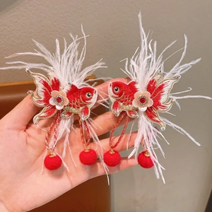 Detail view of Chinese New Year red koi hair clips with embroidery and white feathers