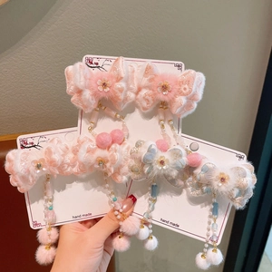 Close-up of winter hair clips with lace butterflies, plush balls and long tassel beads
