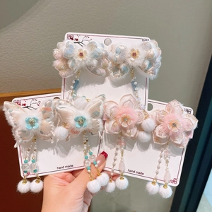 Detailed close-up of handmade Chinese butterfly hair clips with floral embroidery and tassels