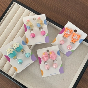 Dettaglio di un set di quattro orecchini a clip a cartone animato per bambini in una scatola