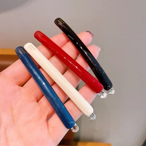 Close-up of elegant acetate hair clips in four colors with gold France Handmade text