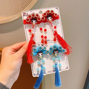 Detailed view of Chinese opera style hair clips with silk tassels and vibrant pom-poms