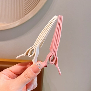 Close-up of cream and pink hair root clips for volume with textured matte finish