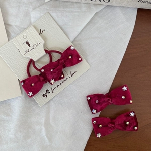 Dettaglio di fermagli ed elastici in velluto bordeaux con stelle di strass lucidi