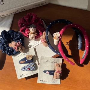 Detail of handmade bow hair accessories with plush bear and rabbit on a set of scrunchies