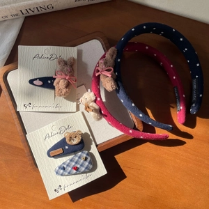 Detail of handmade plush bunny and bear headbands with fabric clips on wooden tray