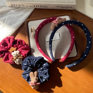 Detail of plush bear and star pattern on pink bow headband and hair scrunchie set