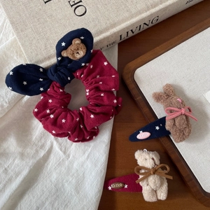 Detailed flat lay of cute plush bear and bunny hair clips with star pattern fabric ties