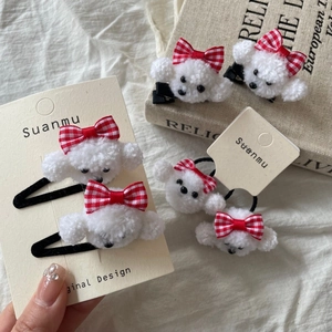 Cute plush puppy hair clip and scrunchie set with red plaid bows on cream fabric