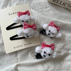 Set of four plush white puppy hair clips with red plaid bows and metal base