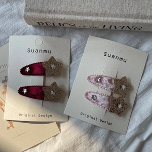 Détail des barrettes en velours avec étoiles rouges et roses sur support Suanmu