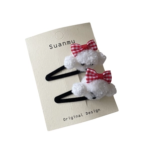 Set of two plush puppy hair clips with red gingham bows on minimalist display card