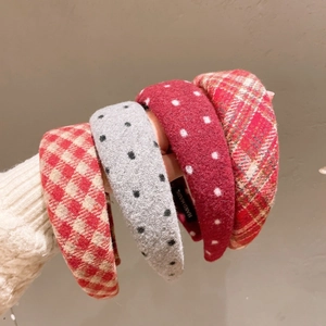 Close-up of thick woolen padded headbands in various red and grey plaid patterns