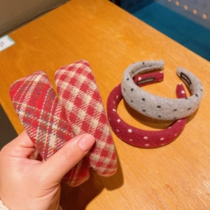 Close-up of four thick wool plaid and polka dot headbands with handmade labels