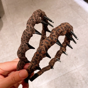 Détail du serre-tête léopard avec pointes noires et dents antidérapantes pour coiffure
