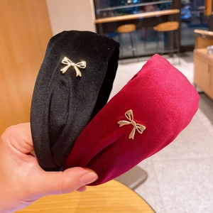 Detail showing velvet headbands in black and burgundy with gold metal bow accents