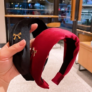 Elegant velvet headband with gold bow detail in black and burgundy for winter styling