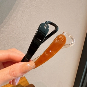 Dettaglio dei fermagli per capelli a banana stile francese in nero e ambra