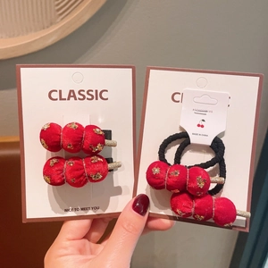 Vue détaillée des barrettes en velours rouge avec paillettes d'étoiles dorées de fête