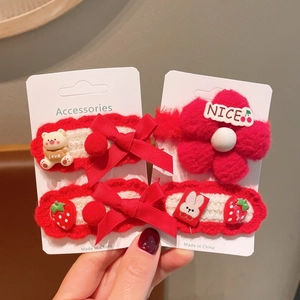 Detail of 4-piece red and white knitted hair clips featuring bows and cute charms