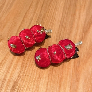 Détail de pinces à cheveux en velours rouge avec paillettes dorées et étoiles
