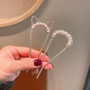 Detailed macro view of elegant pearl hairpins with feline and floral alloy designs