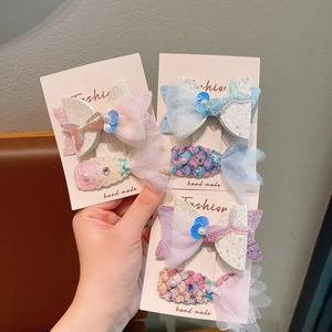 Detail of glittery mermaid tail hair clips with tulle bows and pearls for girls